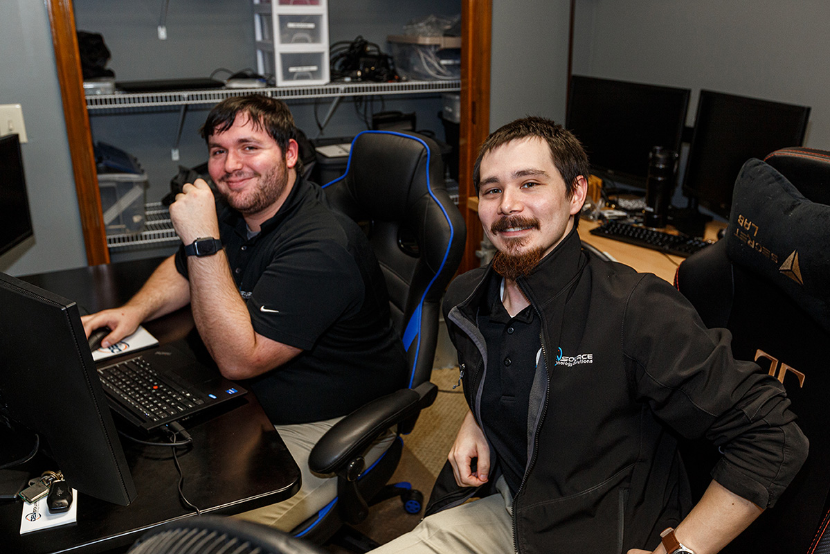Two DEVsource employees witting at a workstation
